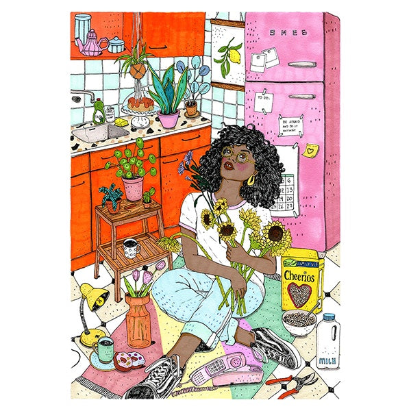 Mujer negra sentada en el suelo de una cocina naranja con nevera Smeg rosa sosteniendo un ramo de girasoles y con muchos objetos alrededor