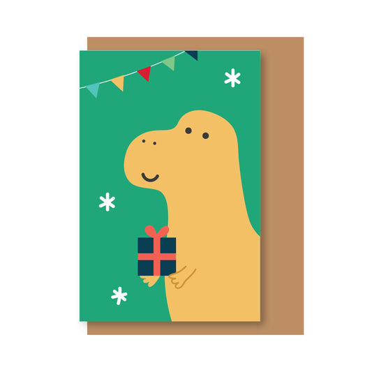 Tarjeta de Navidad con sobre craft y un dinosaurio con un regalo y banderines de colores sobre fondo verde