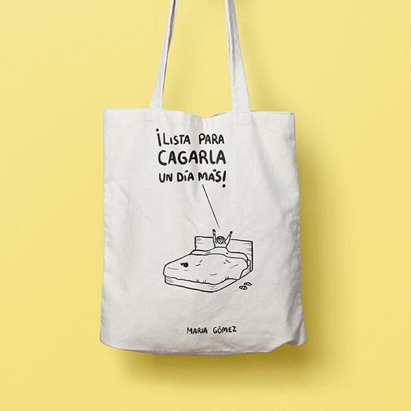 Tote bag con la ilustración de una chica en la cama al despertar que grita "¡Lista para cagarla un día más!"