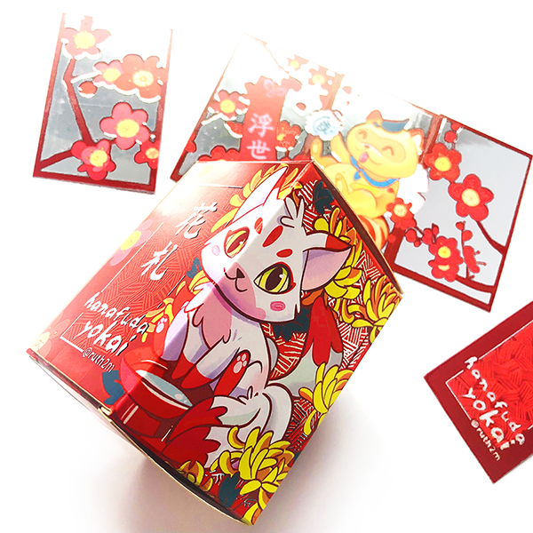 Caja y cartas del juego Hanafuda Yokai ilustrado por Ruth Martínez con temática floral y estilo kawaii