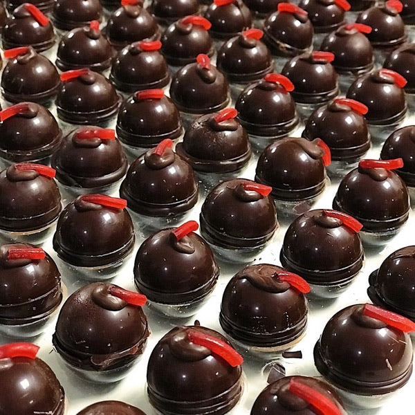 foto de muchas bombetas de chocolate rellenas de cazalla, de la marca Utopick Cacao colocadas sobre una mesa