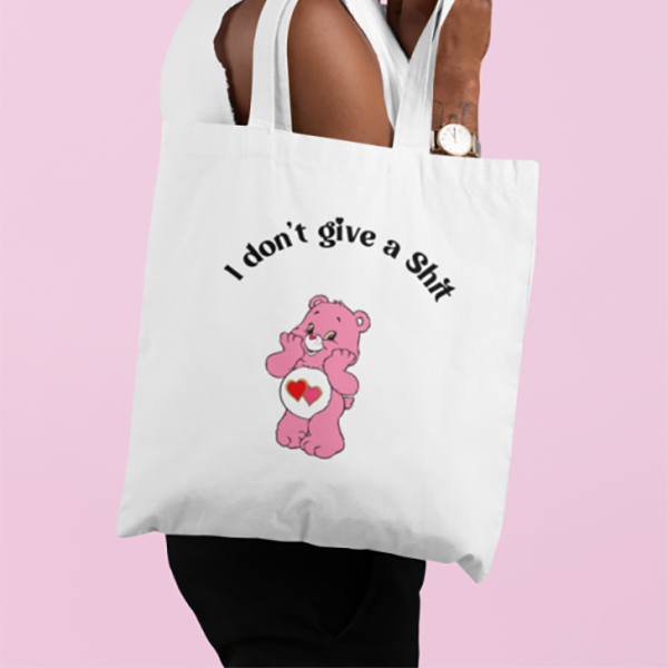 Bolsa de tela en color crudo con la inscripción "I don't give a shit" y un oso amoroso rosa.